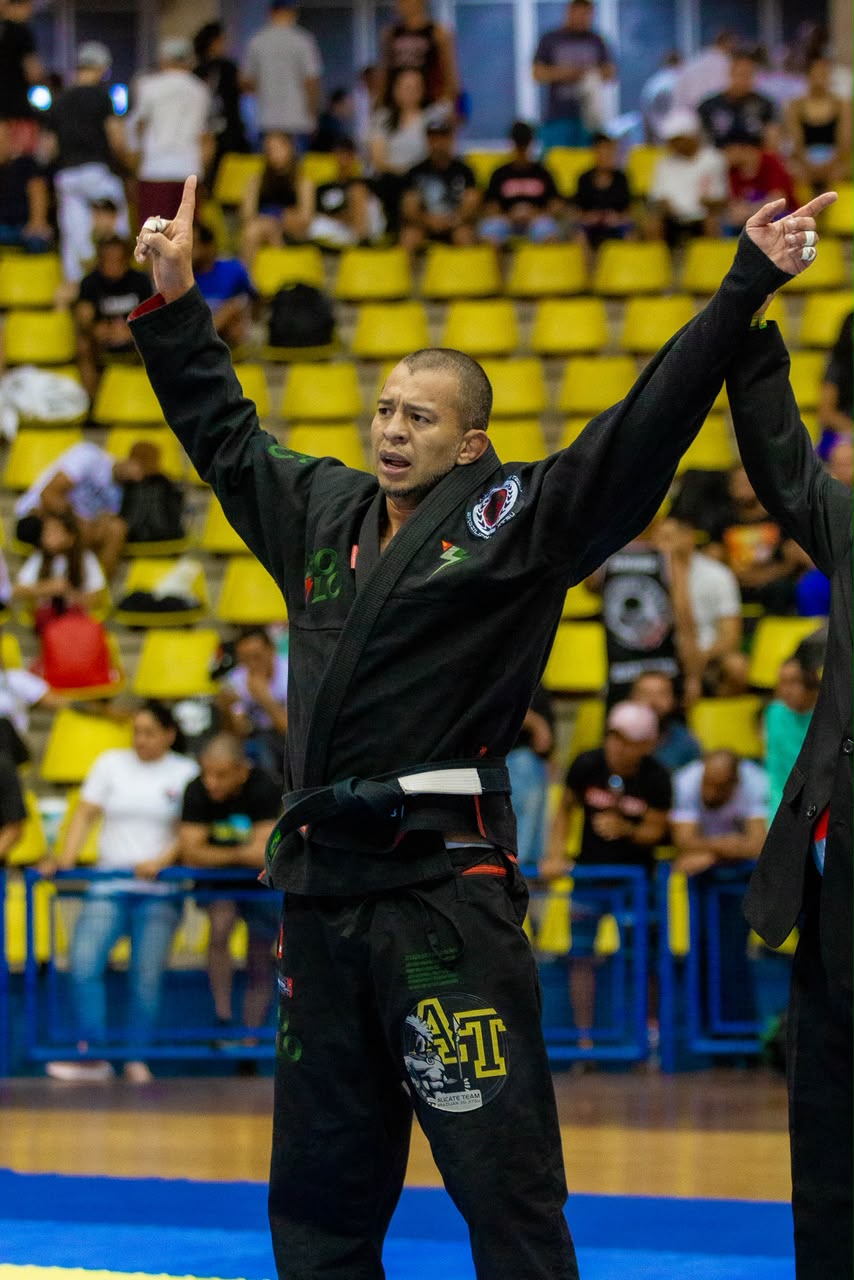 Juliano Alicate de braços erguidos comemorando vitória de kimono